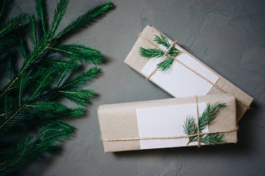 İki hediye kutuları, köknar-ağaç dalları, dekor ile Noel arka plan. Üstten görünüm kopya alanı ile gri arka plan sıvalı.