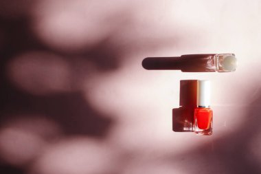 çok renkli tırnak cilaları üstten görünüm, pastel pembe arka plan üzerinde düz yatıyordu. Birçok kavanoz ile çok renkli oje için yuvarlak.