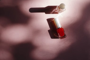 çok renkli tırnak cilaları üstten görünüm, pastel pembe arka plan üzerinde düz yatıyordu. Birçok kavanoz ile çok renkli oje için yuvarlak.