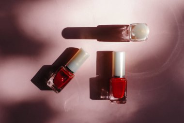 çok renkli tırnak cilaları üstten görünüm, pastel pembe arka plan üzerinde düz yatıyordu. Birçok kavanoz ile çok renkli oje için yuvarlak.