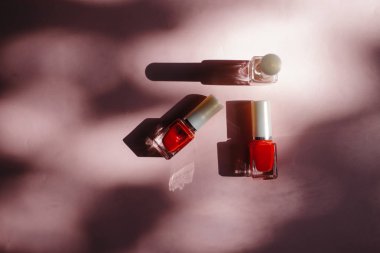 çok renkli tırnak cilaları üstten görünüm, pastel pembe arka plan üzerinde düz yatıyordu. Birçok kavanoz ile çok renkli oje için yuvarlak.