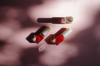 çok renkli tırnak cilaları üstten görünüm, pastel pembe arka plan üzerinde düz yatıyordu. Birçok kavanoz ile çok renkli oje için yuvarlak.