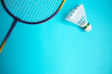 Mekik siki ve badminton raketini mavi arkaplanda kapat.