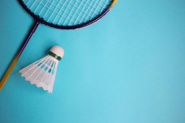 Mekik siki ve badminton raketini mavi arkaplanda kapat.