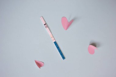 İki şeritler ve pembe kalpler ile pozitif gebelik testi. mavi arka plan, kopya alanı