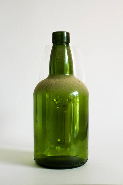 Old dust green wine bottle on white background