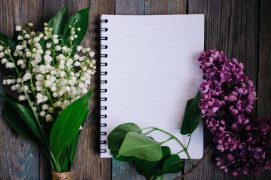 bir fincan çay, fındık, leylak ve ahşap bir masa üstünde bir defter