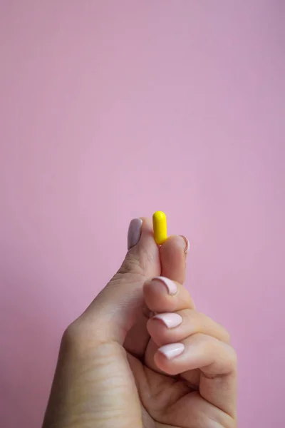 Mujer Mano Sosteniendo Cápsula Píldora Amarilla Sobre Fondo Rosa Concepto —  Fotos de Stock