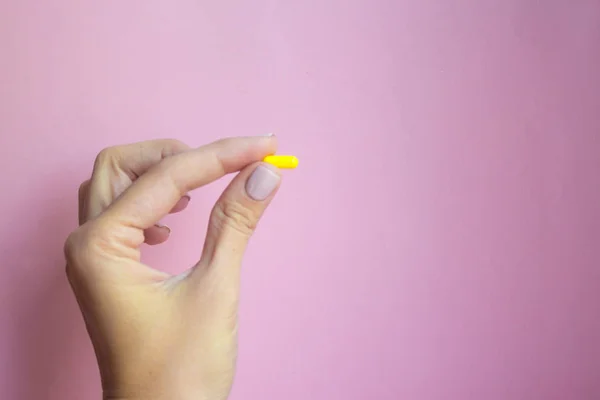 Mujer Mano Sosteniendo Cápsula Píldora Amarilla Sobre Fondo Rosa Concepto —  Fotos de Stock