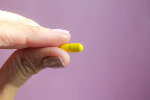 Mujer Mano Sosteniendo Cápsula Píldora Amarilla Sobre Fondo Rosa Concepto —  Fotos de Stock