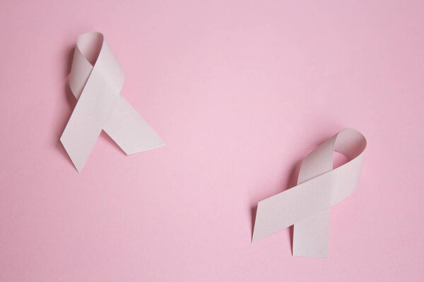 Pink ribbons symbolic bow color for Breast cancer awareness in October month on pink background