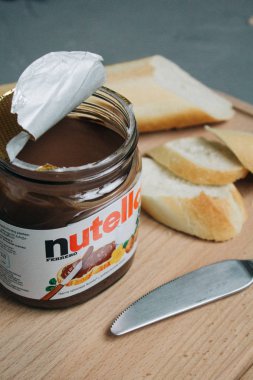 Moskova, Rusya - Jctjber 10, 2018: Kavanoz, Nutella dilimlenmiş fındık baget ve tablo bıçakta ahşap kesme tahtası