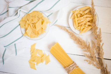 Beyaz ahşap bir masa spagetti makarna çeşitleri Penne, porçini, yöresel yemekler