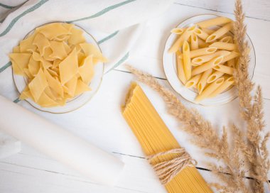 Beyaz ahşap bir masa spagetti makarna çeşitleri Penne, porçini, yöresel yemekler