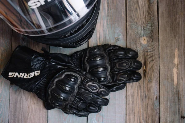 Fryazino, Rusya - 06 18 2018: Motosiklet binici aksesuarları. kask ve eldiven ahşap masa, üstten görünüm