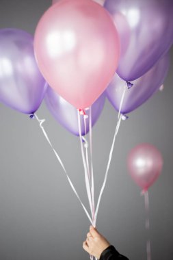 pembe ve mor balon tutan kadın el