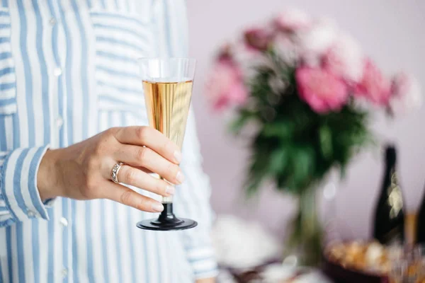 Mano Delle Donne Tenendo Bicchiere Champagne Sullo Sfondo Del Tavolo — Foto Stock