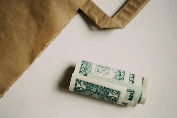 Kraft paket beyaz arka plan üzerinde nakit dolar parayla.