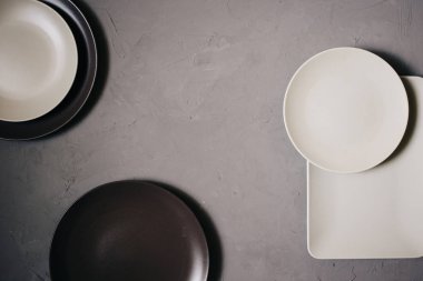 Set seramik tabak kahverengi ve sütlü beyaz renkli, gri arka plan üzerinde yukarıdan