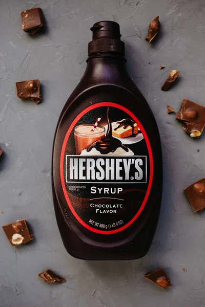 Moskova Rusya - 11 14 2018: şişe Hershey's çikolata şurubu. gri zemin üzerine çikolata parçaları