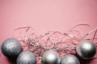 Noel kompozisyon. Pembe bir arka plan üzerinde gümüş Noel dekorasyonu topları. Üstten görünüm, kopya alanı
