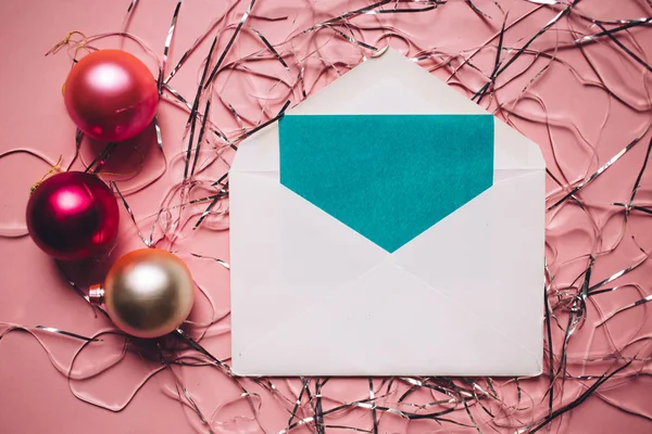 クリスマスの組成物 カードと封筒 ピンクの背景のクリスマスの赤とピンクの装飾 — ストック写真