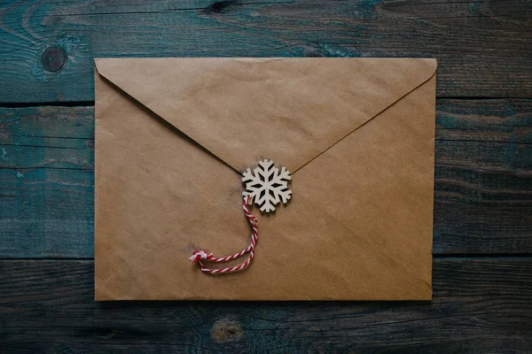 letter to Santa Claus, envelope with wooden Christmas decor in the form of wax seal, dark wooden background