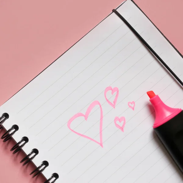 heart sign on notepad and pink marker on pink background, a love note using a pink marker, valentine\'s day