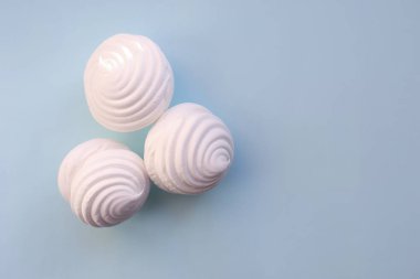 Mavi zemin üzerine beyaz Marshmallow. Düz kopya alanı ile yatıyordu