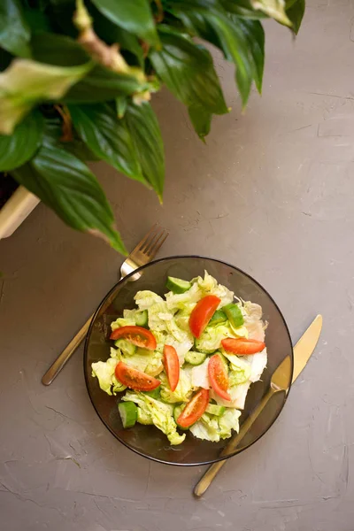 Ensalada Saludable Verduras Frescas Tomates Pepinos Iceberg Cubertería Spathiphyllum Fondo — Foto de Stock