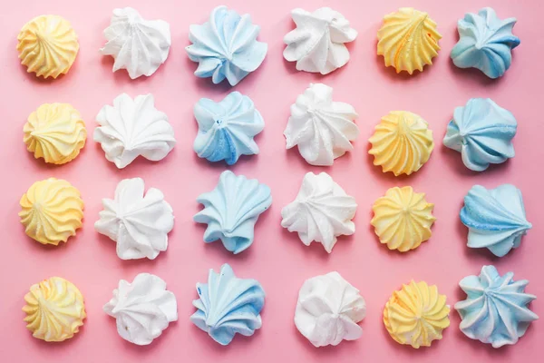 Multicolored meringue on a pink pastel background. Delicious dessert. Colorful handmade meringue. — Stock Photo, Image