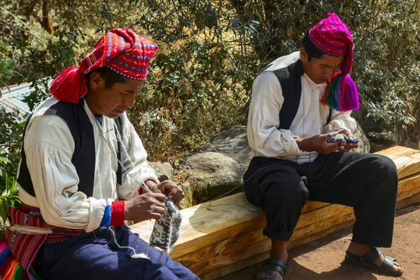 Taquile insel, titicacasee, peru - 04. september 2019 - zwei ältere eingeborene männer der taquile insel stricken einen traditionellen hut. auf der taquile insel stricken die männer und die frauen weben. — Stockfoto