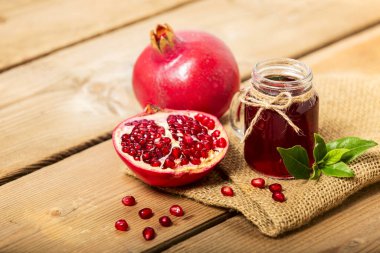 Bir bardak nar suyu ve ahşap masada taze nar meyveleri. Vitamin ve mineraller. Sağlıklı içki konsepti.