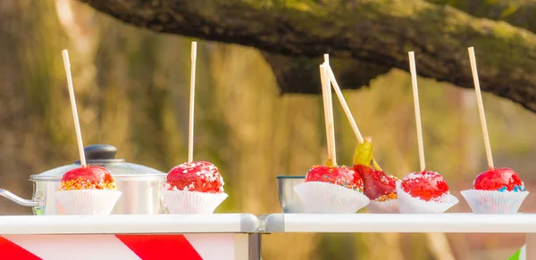 Sokak gıda rac üzerinde renkli kırmızı karamel elmalar