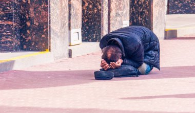 Saint-Petersburg, Rusya, 26.04.2018: İnsanlar kaldırımda yalan biraz para bağış için yalvarıyor evsiz serseri bir adam