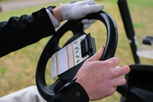 Mężczyzna jazdy wózkiem golfowym, karty wyników i rąk w centrum uwagi — Zdjęcie stockowe