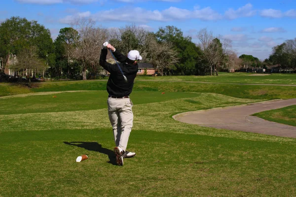 Golfer beendet seinen Schwung, nachdem er einen Ball vom Abschlag getroffen hat — Stockfoto