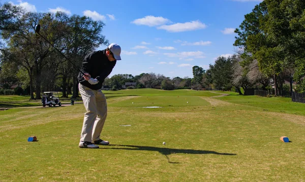 Golfspelare svänga för att driva sin tee sköt med hit bollen i ram på — Stockfoto