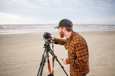 Plaj fotoğrafçı dalgalar ve Bay gökyüzü Shoot bir tripod kullanarak