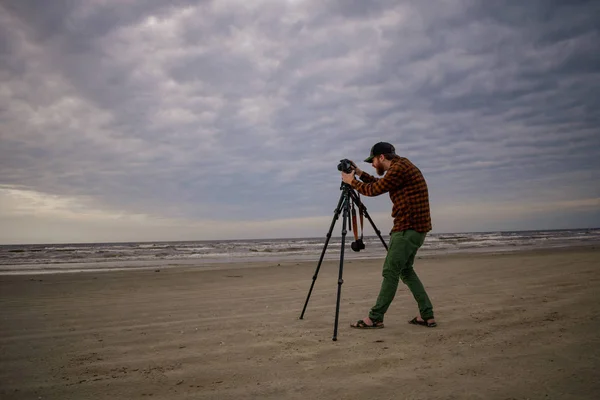 Fotograaf het opzetten van apparatuur op het strand — Stockfoto