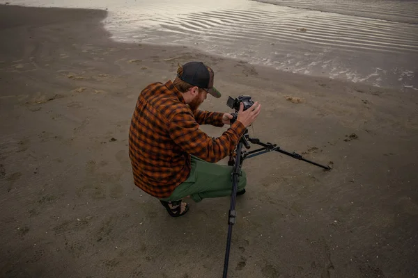 Fotógrafo de playa usando un trípode para disparar olas y Bay Sky —  Fotos de Stock
