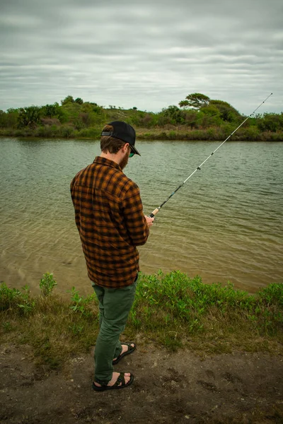 Pescador olhando para o seu elenco na água — Fotografia de Stock