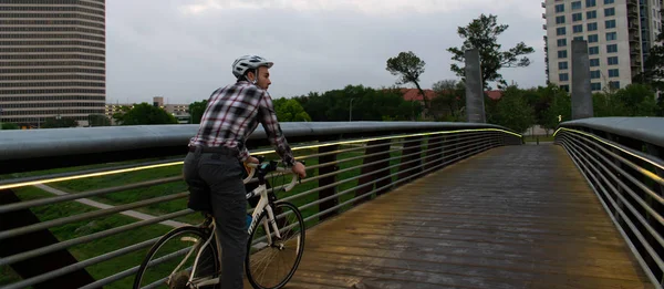 Man Biking To Work Over City Bridge
