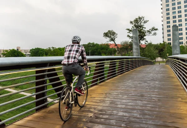 Man Biking To Work Over City Bridge