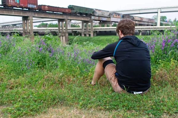 Homem assistindo um trem em um campo de flores - Bluebonnets Texas — Fotografia de Stock