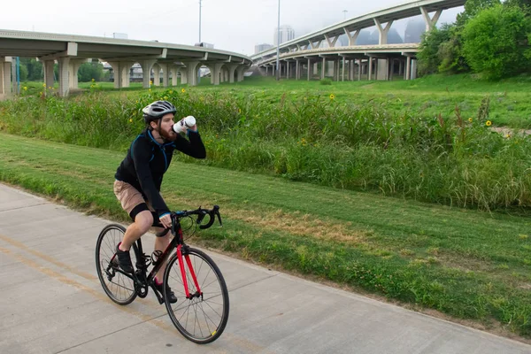 Férfi kerékpározás és vizet inni egy nyom — Stock Fotó