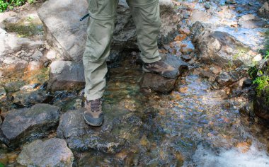 Yürüyüşçüler bir akarsu straddling Boot