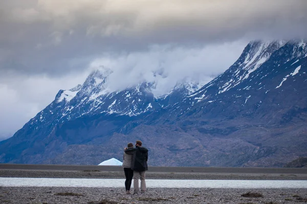 Paar staande in ontzag voor Torres Del Paine Mountain Range en Gl — Stockfoto