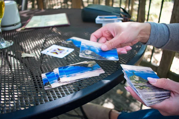 Mujer joven repartiendo cartas oustide en una mesa —  Fotos de Stock