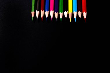 Siyah arkaplanda renkli kalemler